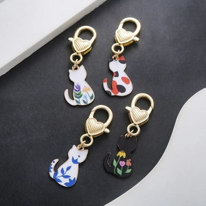 Detailed view of four colorful enamel cat charms with golden heart-shaped lobster clasps