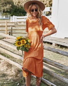 Détail d'une robe longue orange à ourlet volanté et manches courtes pour les vacances