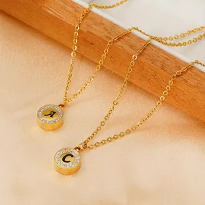 Gold 18K stainless steel necklaces with diamond-encrusted letters A and C on velvet