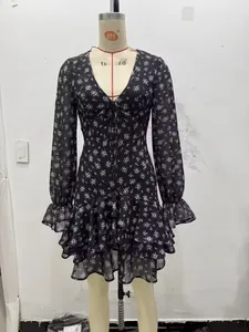 Detail van gebloemde chiffon jurk met diepe V-hals, strikbandjes en gelaagde ruches