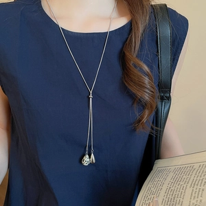 Y-shaped necklace with silver drop pendants and spotted stone shown on deep blue clothing