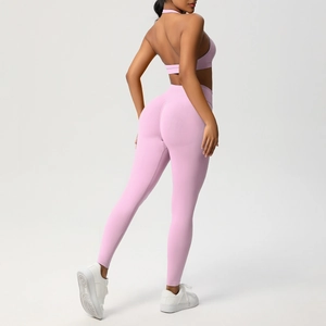 Vista posteriore del set yoga rosa a costine con reggiseno allacciato al collo e leggings a vita alta