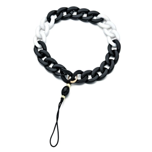 Detail view of black and white acrylic chunky chain link with gold metal ring connector