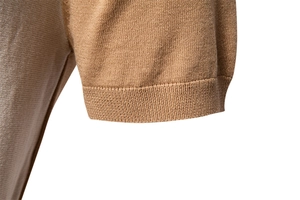 Close-up of camel knit polo sleeve featuring 1x1 ribbed cuffs and high-density texture