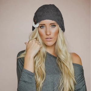 Detailed view of women's dark gray knitted beanie featuring lace flower and leaf patterns