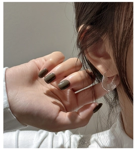 Close-up of S925 sterling silver fan-shaped earrings with textured radial pleats on model
