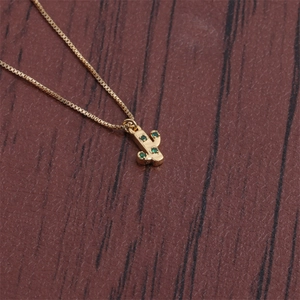 Close-up of gold plated cactus pendant with green crystal inlays on box chain necklace