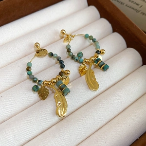 Detail of 14K gold plated earrings with turquoise beads and feather leaf pendants
