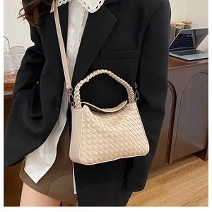 Detail showing handwoven cream crossbody bag with woven handle and shoulder strap