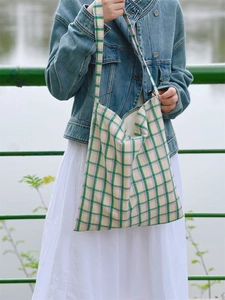 Detailed view of green and lavender plaid cotton canvas tote bag worn with a casual outfit