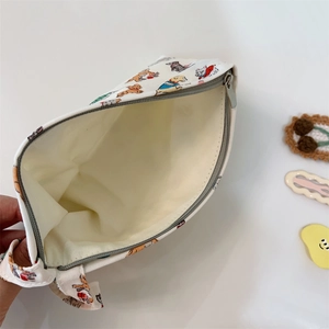 Vue détaillée d'une pochette en toile avec fermeture éclair et imprimés de chiens