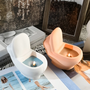 Macro shot of creative toilet-shaped candles lit with blue and wax liquid details