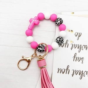 Close-up of pink and white silicone bead keychain with Jesus cross and leopard print bead