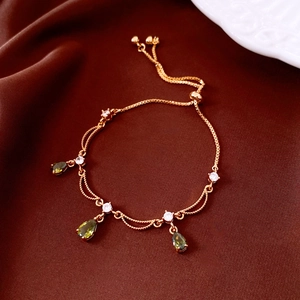 Detail eines 18k vergoldeten Armbands mit grünen Tropfensteinen und Diamanten