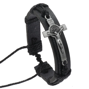 Detail of black woven leather bracelet featuring metal cross and adjustable knot