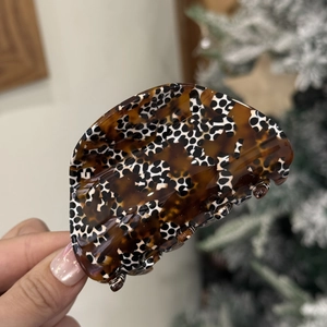 Macro shot of brown leopard print acetate hair claw clip with elegant stripe texture