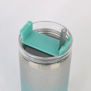 Detail of the transparent lid with teal flip cover and grey straw on a glitter tumbler