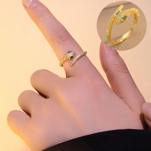 Detailed close-up of a gold snake ring with green zircon eyes and micro-pave setting