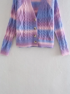 Close-up of cable knit texture and buttons on a colorful gradient tie-dye cardigan