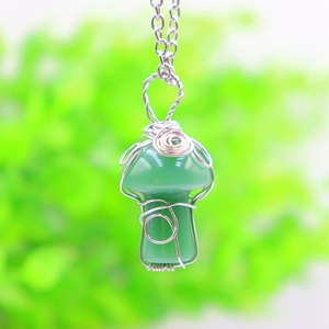 Macro shot of green crystal mushroom pendant with handmade silver wire wrapping detail