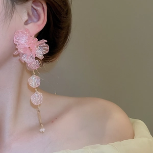 Detailed view of pink floral tassel earrings with frosted acrylic petals on model