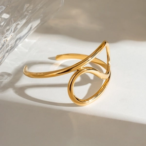 Minimalist gold irregular twisted open bangle with polished fluid metal lines