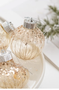 Close-up of champagne gold Christmas ball with sequins and vertical stripes detail