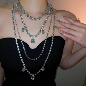 Detail of multi-layered silver tassel necklace with rhinestones and square crystals