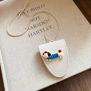 Detail of off-white lychee texture leather key pouch with a cute cartoon dachshund charm