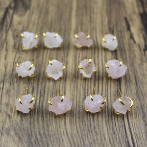Detail of rose and clear quartz claw stud earrings with natural raw stone texture