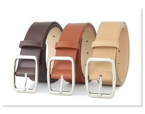 Detailed view of leather belts in dark brown, reddish brown, and beige with silver buckles