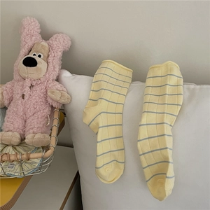 Morandi yellow cotton crew socks with blue stripes on a soft white pillow background