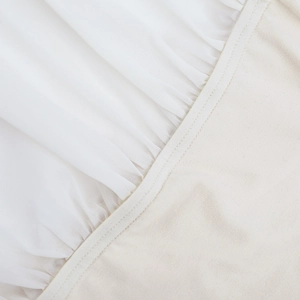 Makroaufnahme von cremefarbenem Netzstoff und weichem Strick an einem Bodycon-Kleid