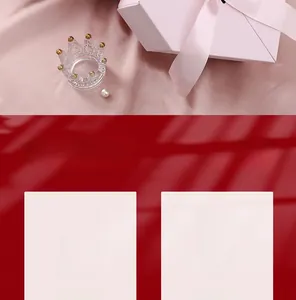 Detailed view of crown shaped glass ring holder with gold accents and pink gift box