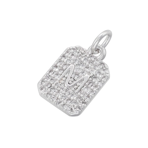Macro shot of silver square pendant with cubic zirconia pavé and letter M detail