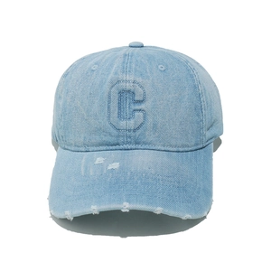 Macro detail of high-quality washed denim baseball cap with distressed brim and embroidered C