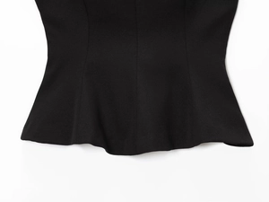 Close-up of the wavy hem detail on a sexy black slim-fit top with high-density fabric
