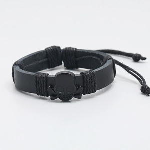 Men's black skull leather bracelet with woven rope details and adjustable cord closure