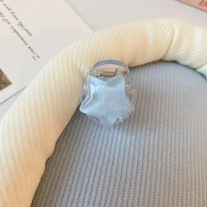 Gros plan d'une pince à cheveux étoile bleue pailletée avec ressort métallique