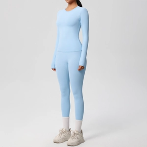Dettaglio del set sportivo celeste con maglia a maniche lunghe e leggings su una modella