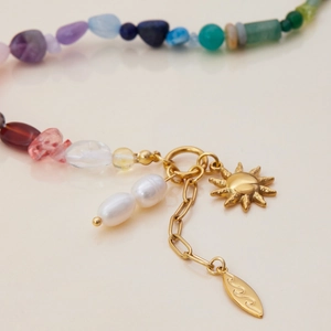 Detail of star-themed bracelet with semi-precious beads, pearls, and golden charms