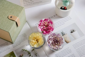 Top view of three preserved flower crystal balls in a gift box on a magazine