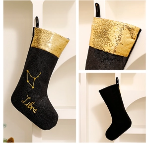 Detail of Libra zodiac Christmas stocking featuring black velvet and gold sequins