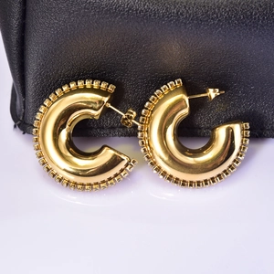 Detail of 18K gold plated C-shaped earrings with fine cubic zirconia border accents