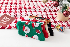 Flache Ansicht von fünf Weihnachts-Baumwollsocken mit Weihnachtsmann- und Elchmustern