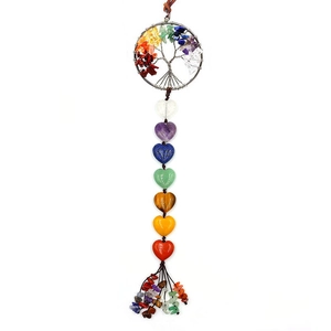 Macro detail of Tree of Life hanging ornament with seven chakra crystals and heart stones