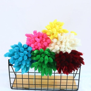 Assorted colorful dried gemstone grass flowers in a stylish metal and wood basket