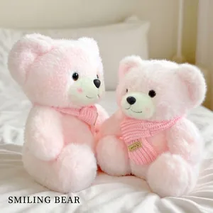 Pair of fluffy pink teddy bears with knitted scarves on white bedding decor
