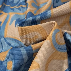 Close-up of ethnic print mesh fabric showing intricate blue and gold floral patterns