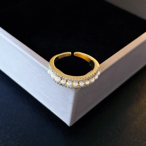Detailed macro shot of a gold-plated open ring featuring rows of small white pearls